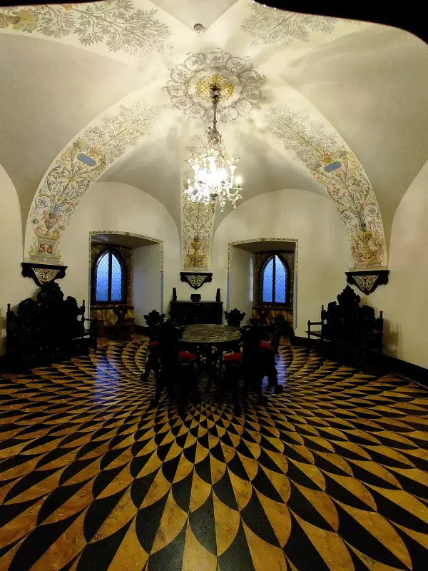 A castle hall with a geometric inlaid floor and a vaulted ceiling